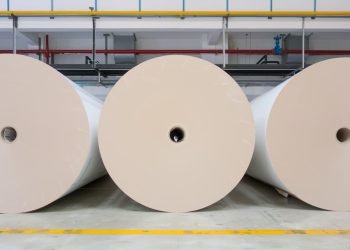 Large paper rolls stored in a modern packaging production facility