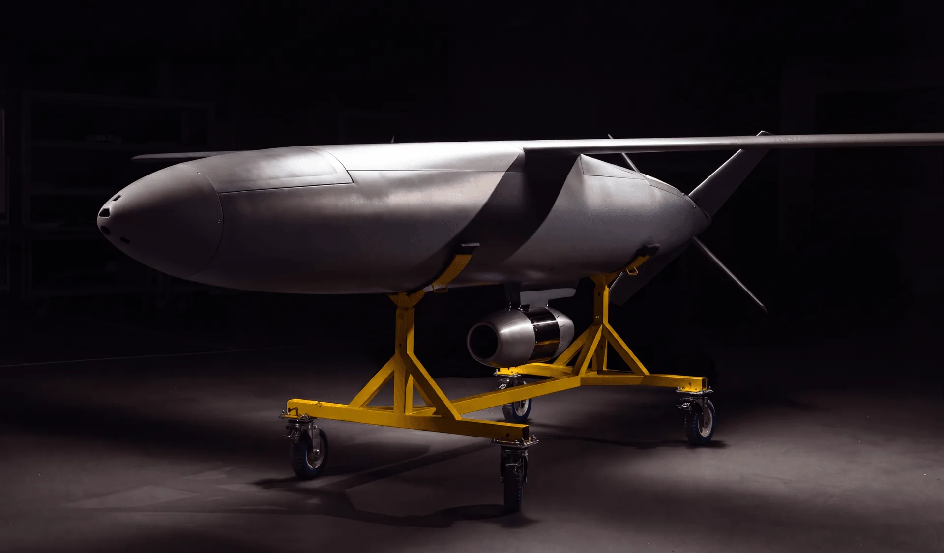 Covenant Anthem cruise missile resting on a yellow wheeled ground handling cart inside a darkened facility